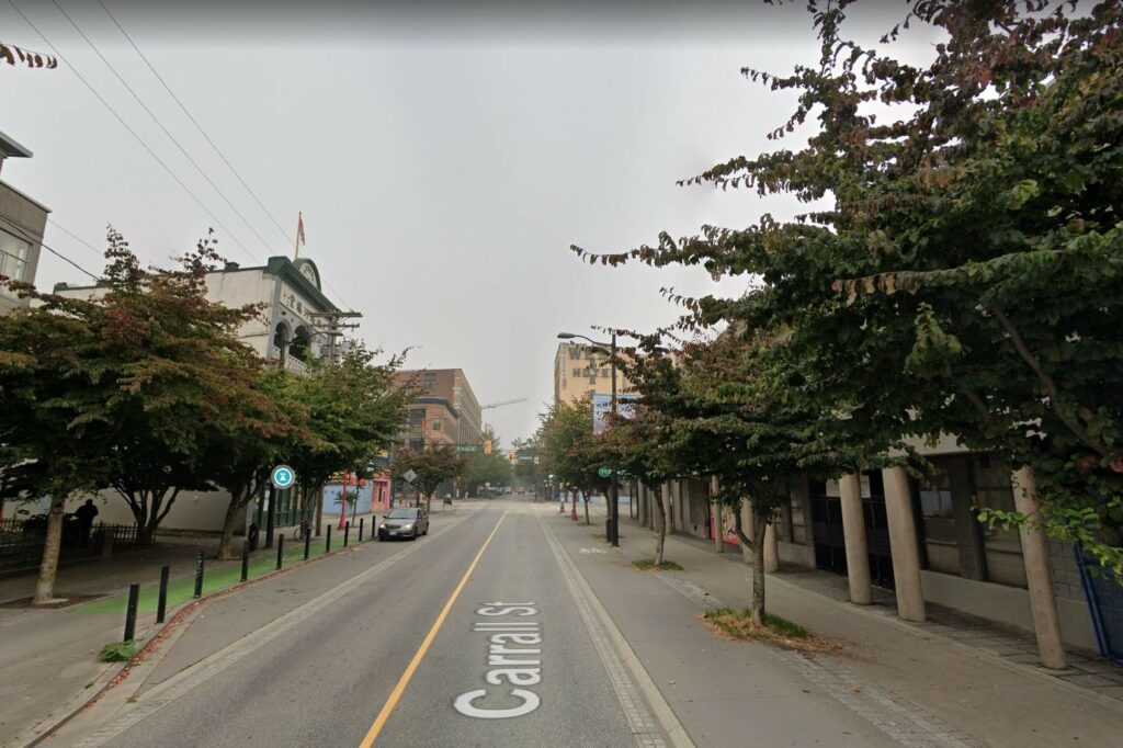 Overcast photo of Carrall Street looking down the empty street. Trees on the side, grey skies.