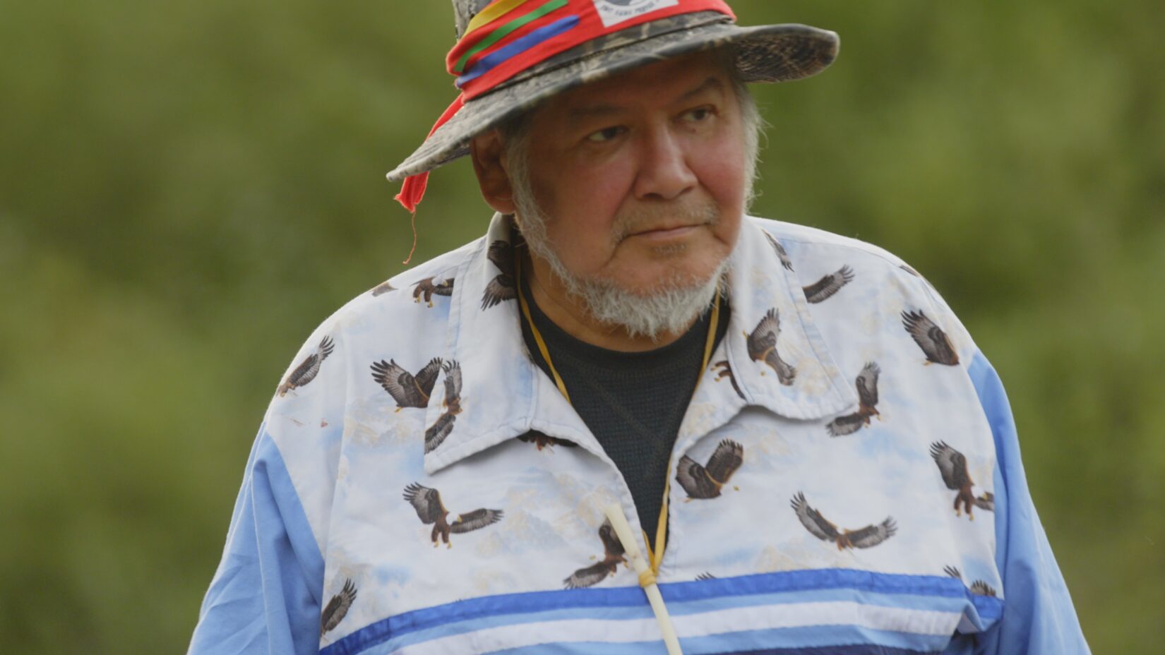 Film still of Wilfred Buck in his eagle shirt with whistle.