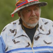 Film still of Wilfred Buck in his eagle shirt with whistle.